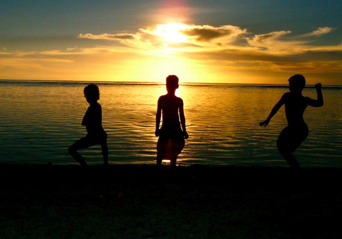 Sunset with children playing in the water